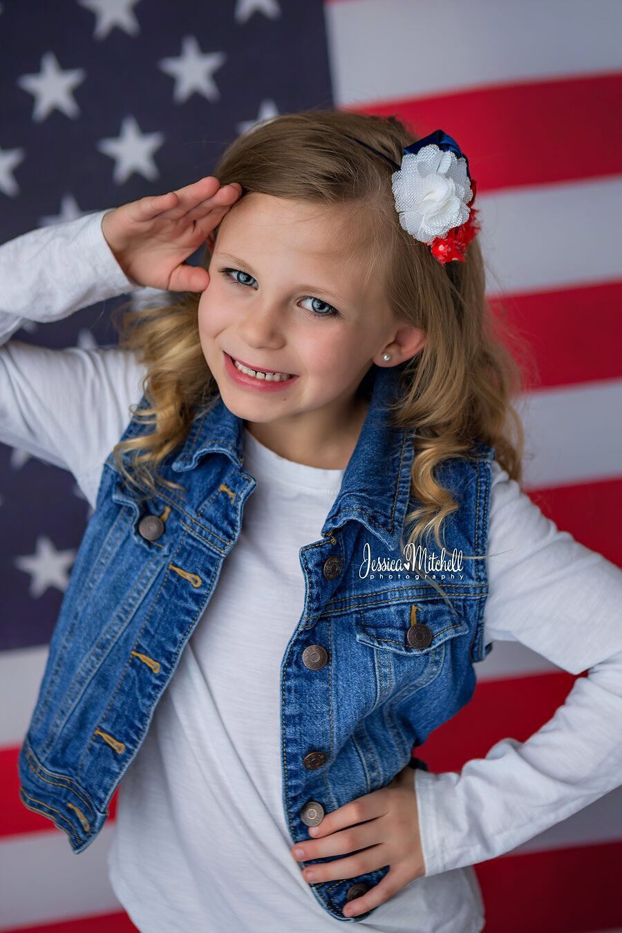 Addyson Mitchell posing in front of American Flag for Beauty Pageant Head shots.